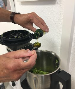 Olivenöl wird in den Mixbehälter zu den zerkleinerten Zutaten gegeben